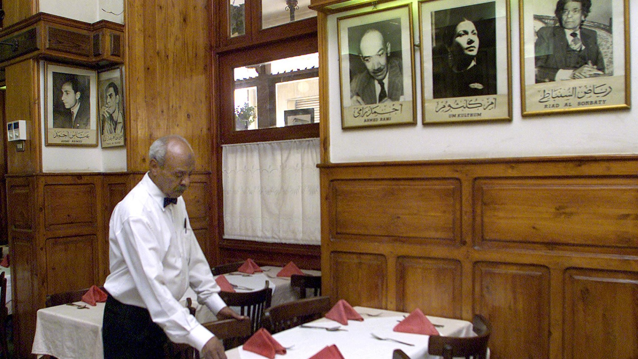  An Egyptian waiter "uncle Filil" prepares a table at the historical Cafe Riche in Cairo on 17 June 2001 (AFP)