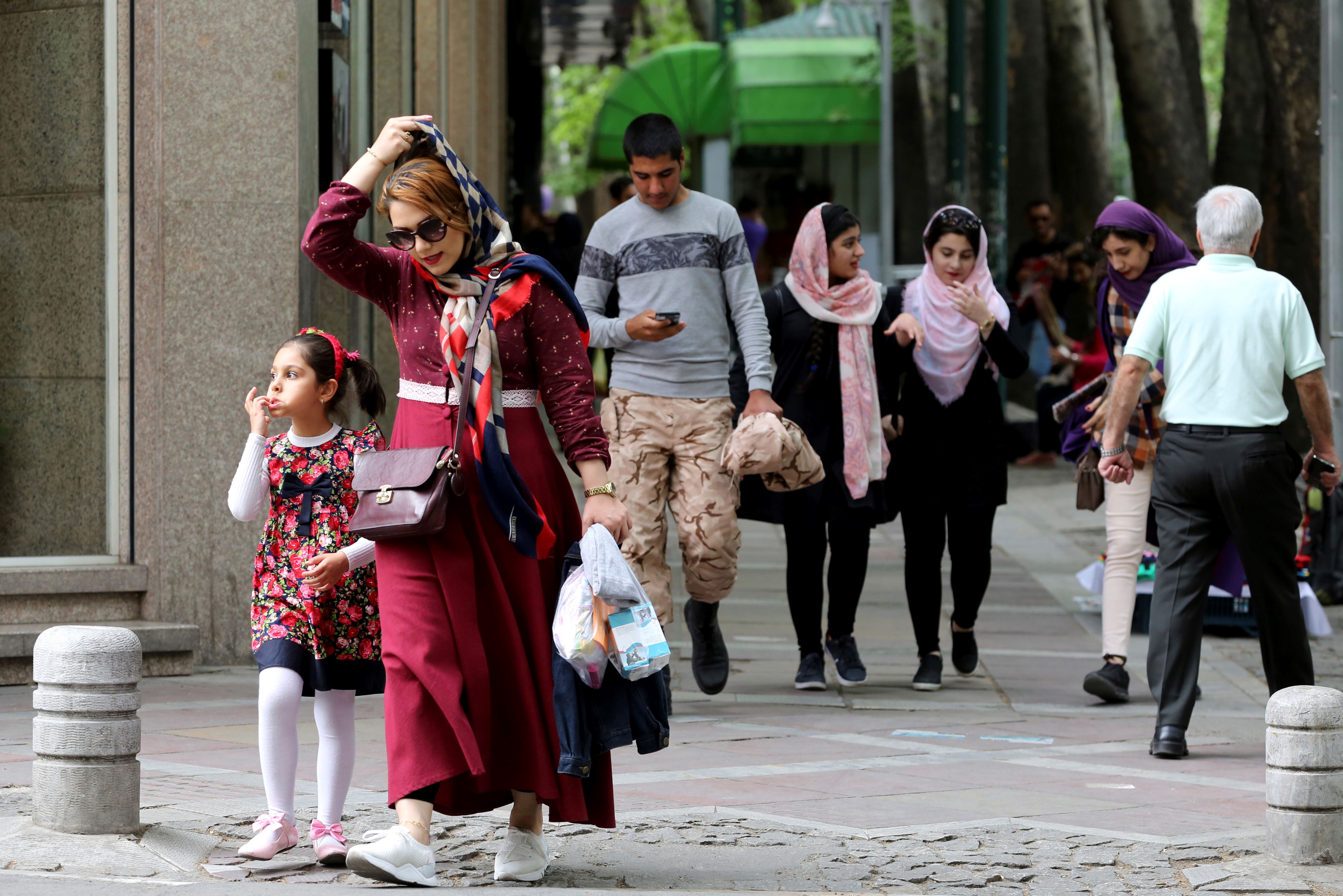 Iranians walk in Valiasr Street in northern Tehran on 8 May (AFP)