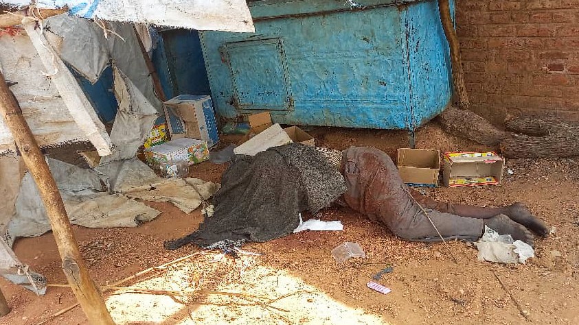 Un cuerpo cubierto frente a una casa en el-Geneina, 16 de junio (AFP)
