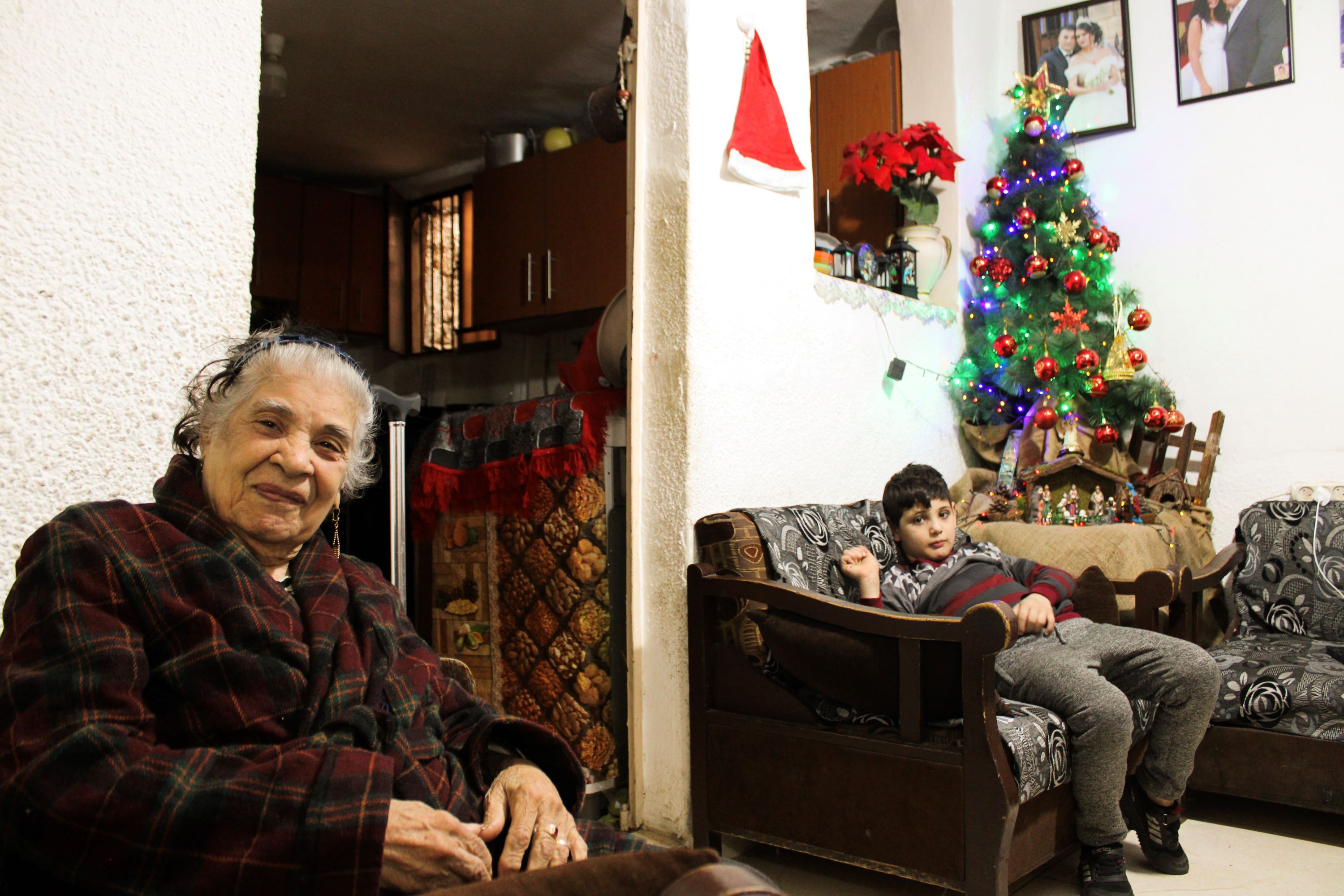 Marie Haddad and one of her grandsons in their home in Tyre’s Christian neighbourhood (Hanna Davis/MEE)