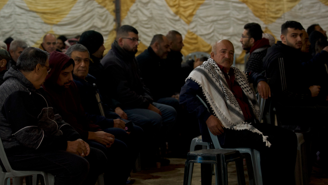 Hombres palestinos se reúnen en el campo de refugiados de Aqbat Jabr, Jericó, para llorar a los cinco jóvenes locales asesinados por las fuerzas israelíes en un ataque mortal el lunes 6 de febrero de 2023 (MEE/Akram al-Waara)