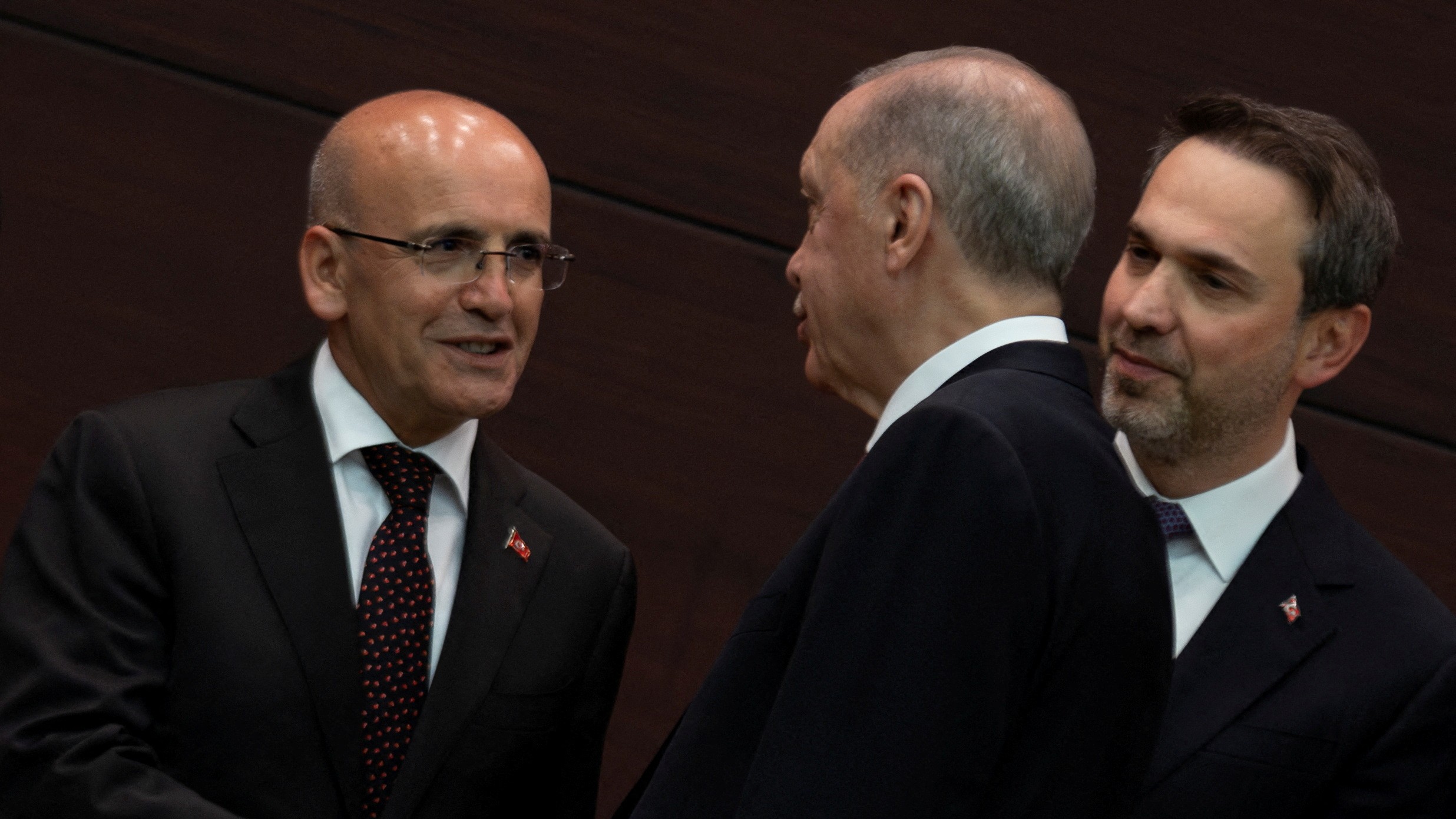Turkish President Recep Tayyip Erdogan shakes hands with the new Treasury and Finance Minister Mehmet Simsek on 3 June (Reuters)