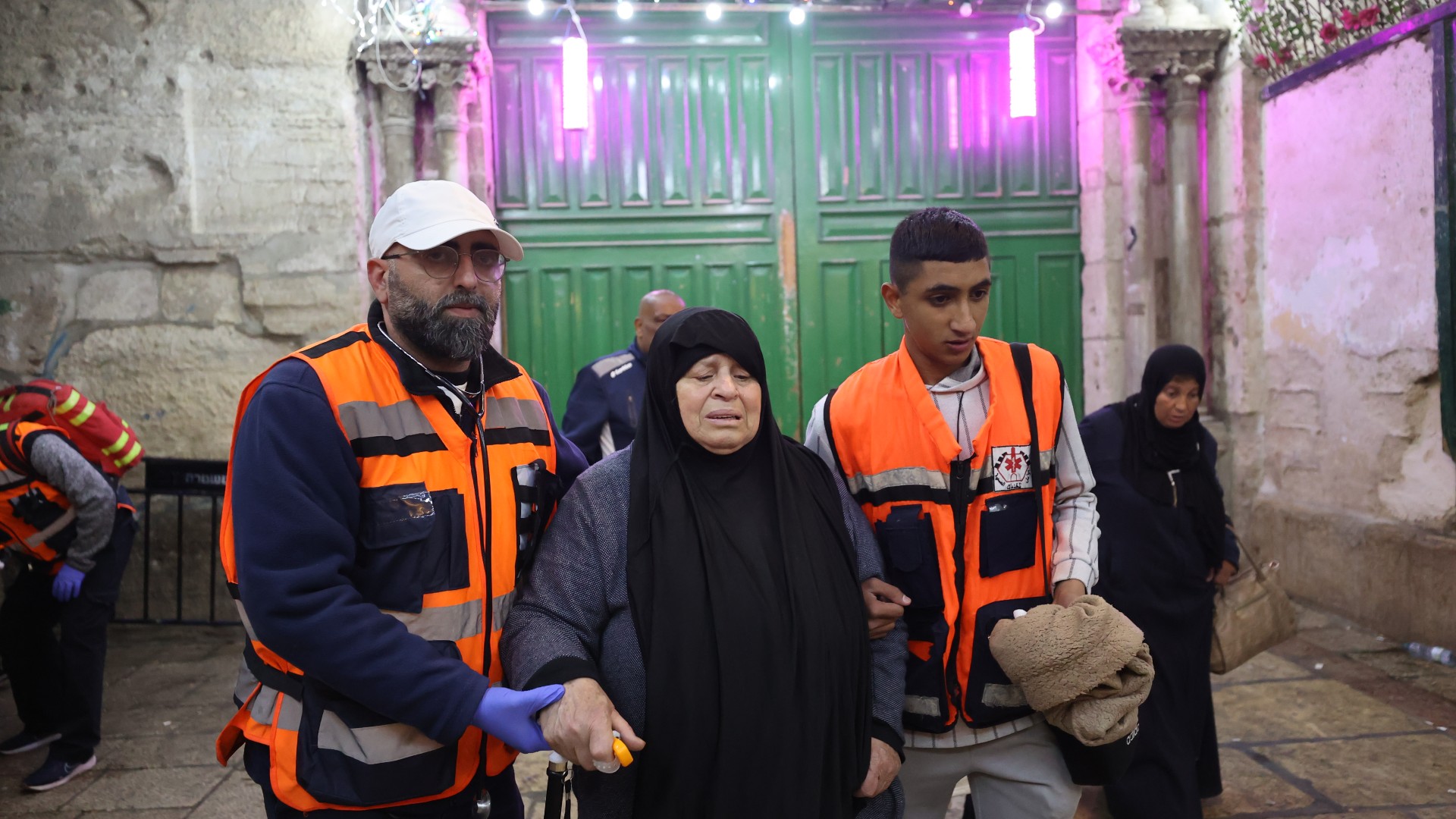 مسعفون فلسطينيون يساعدون نساء محاصرات في الاعتداء الإسرائيلي على المسجد الأقصى عند بوابة السلسلة في القدس الشرقية (وكالة الأناضول)