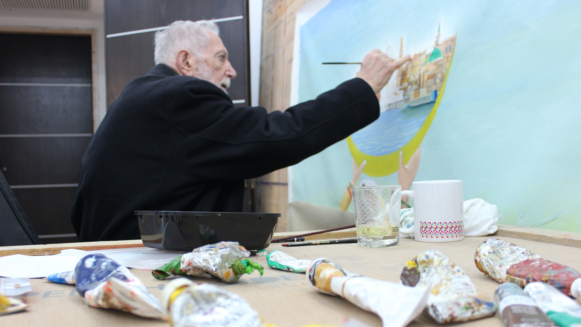 Sliman Mansour travaille sur un nouveau tableau dans son atelier de Ramallah (MEE/Nadda Osman)