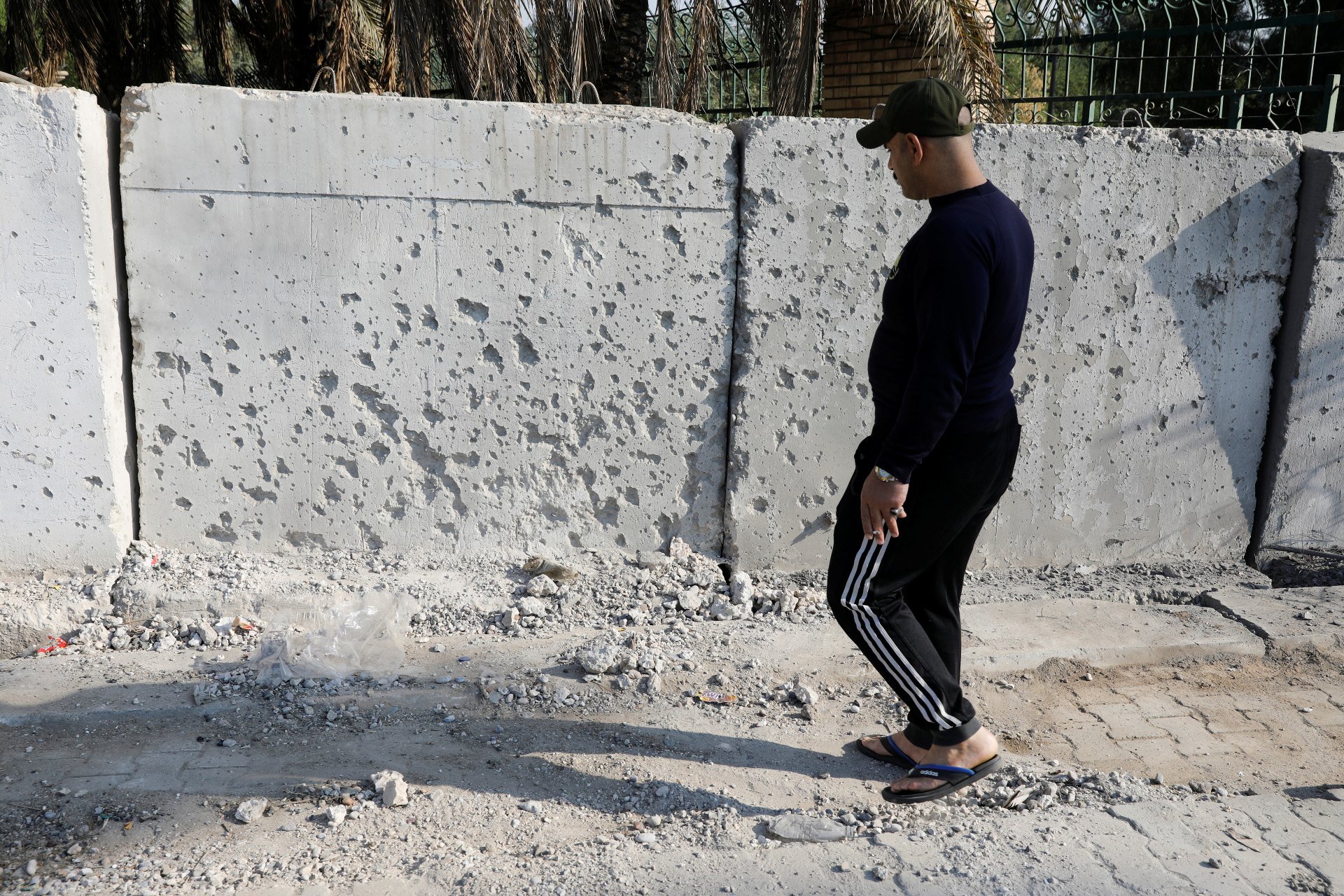 Un homme observe les dégâts d’une attaque à la roquette dans la zone verte de Bagdad (Reuters)