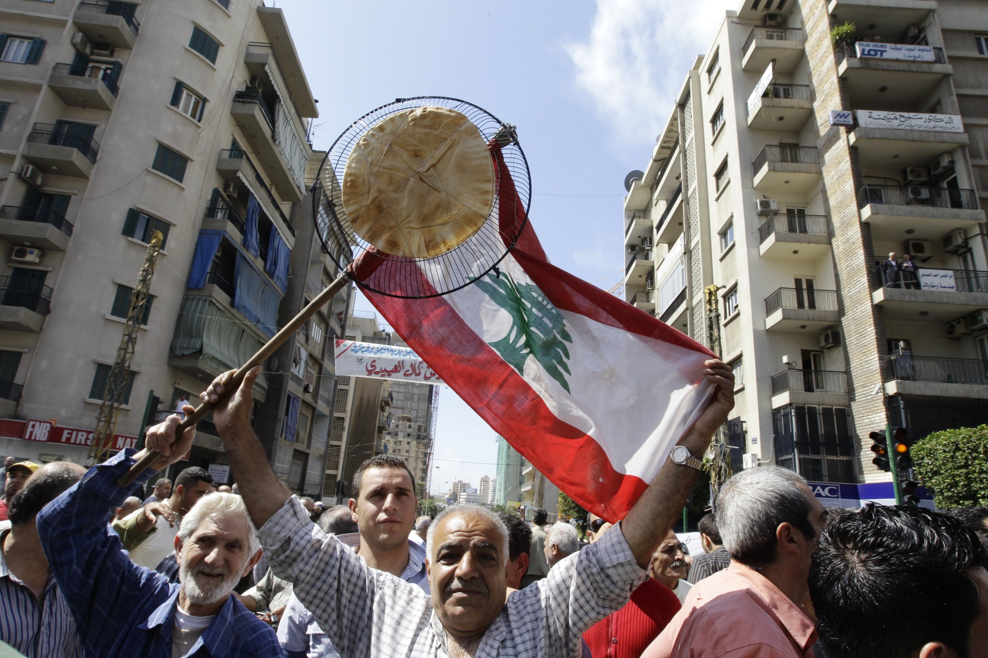 Lebanese bus and taxi drivers carry a Lebanese flag and a flatbread during an April 2010 rally in Beirut protesting fuel prices (AFP)