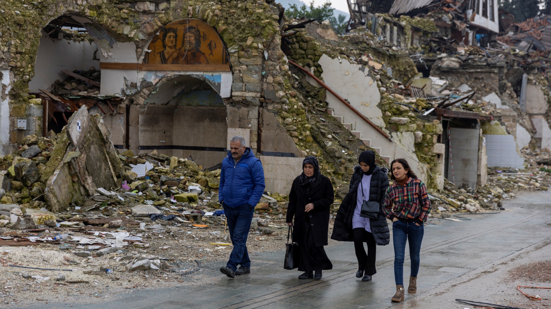 Des personnes marchent devant des maisons détruites par le séisme de 2023, à Hatay, le 5 février (Reuters/Umit Bektas)