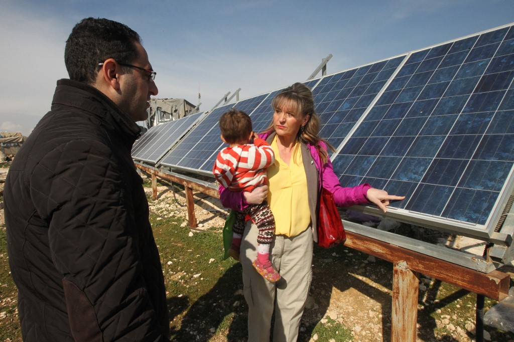 Martina Anderson, membre du Parlement européen, devant des panneaux solaires donnés par l’UE lors d’une visite de députés européens dans le village palestinien de Susya, au sud-est d’Hébron, le 10 février 2016 (AFP)