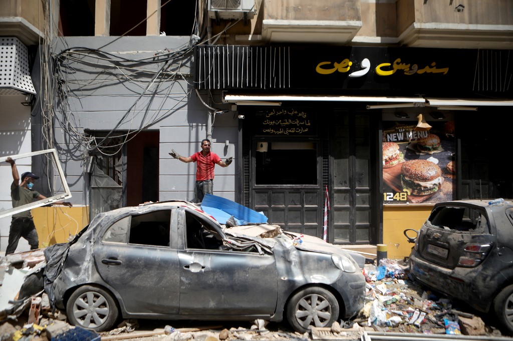 A man removes debris in Beirut’s Mar Mikhael neighbourhood on 7 August (AFP)
