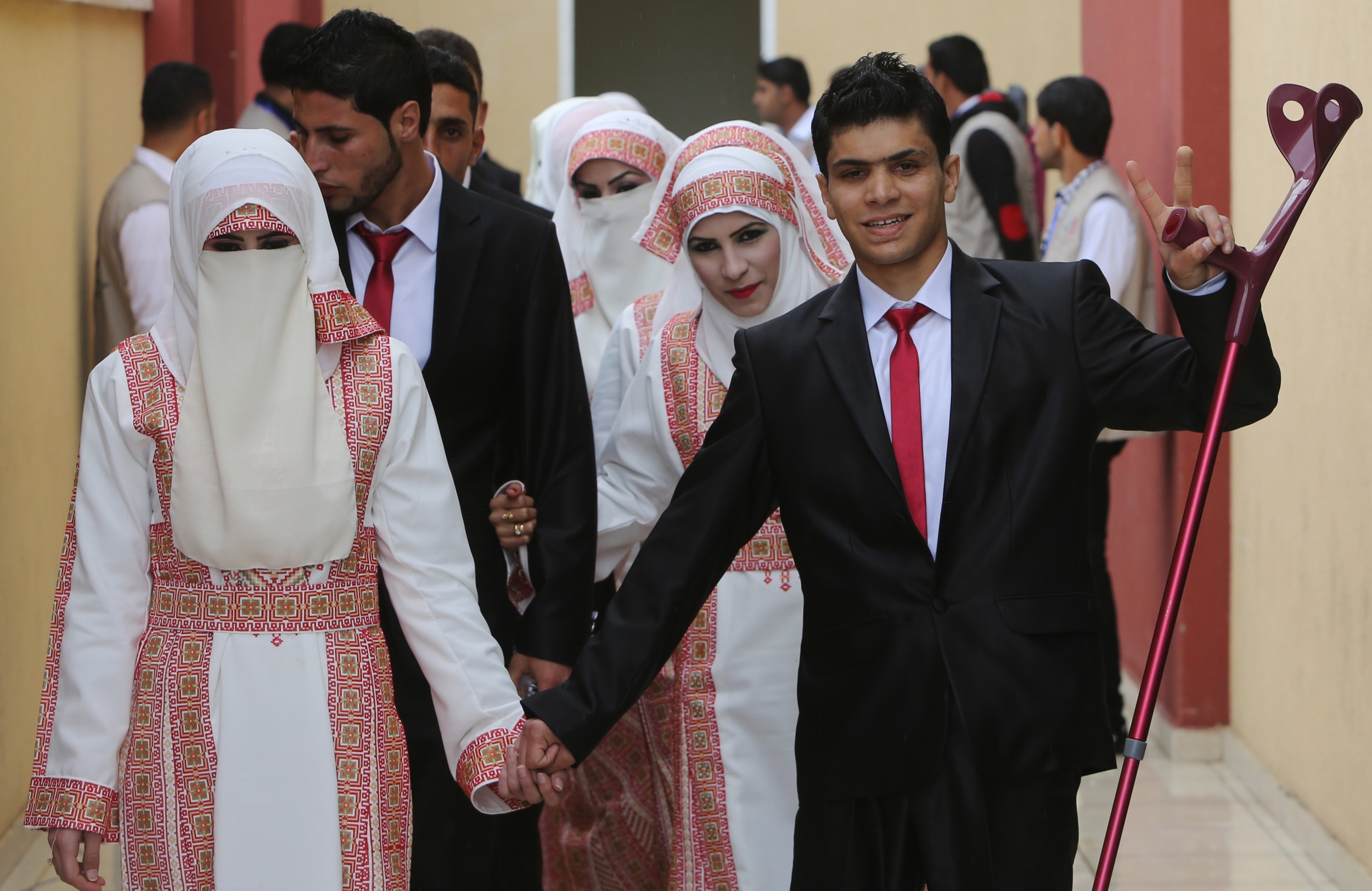 Palestinian brides and grooms take part in a mass wedding ceremony in Gaza City funded by an Emirati governmental organisation on 11 April 2015 (AFP)