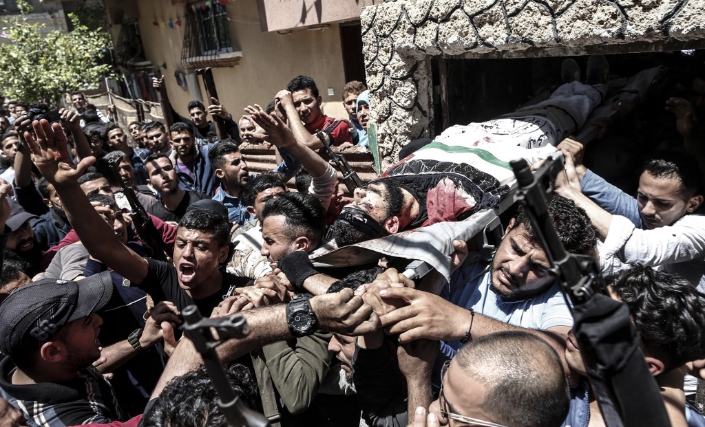Mourners carry the body of a 22-year-old Palestinian killed during a protest in the Gaza Strip on 4 May (AFP)
