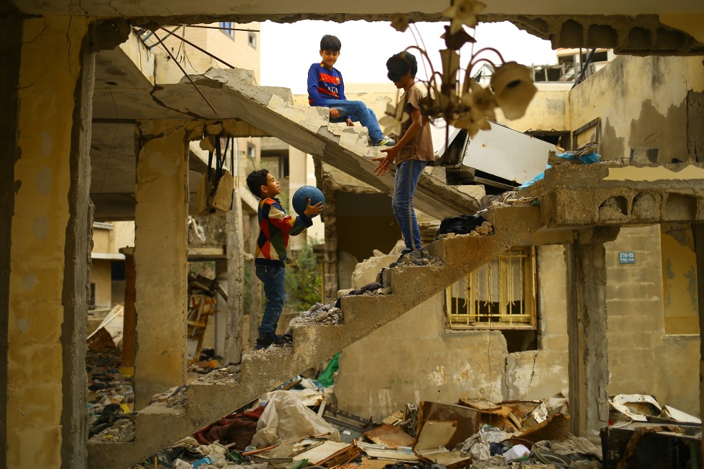 Palestinian children play amid the ruins of a building destroyed during the 2014 Israeli assault on Gaza (AFP)