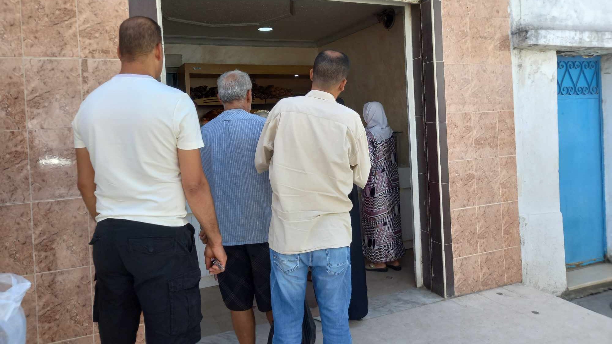 Des Tunisiens font la queue pour acheter du pain dans une boulangerie de la capitale Tunis, le 7 août 2023 (MEE/Stephen Quillen)