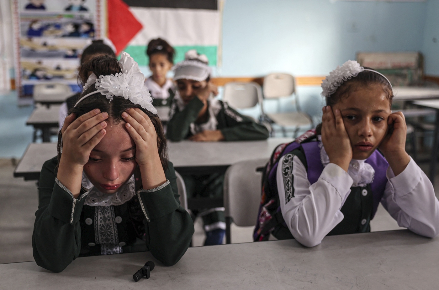 Classmates of Palestinian girl Lian al-Shaer, who was killed in an Israeli air strike in August, mourn her death on the first day of school after the summer holiday, in Khan Yunis in the southern Gaza Strip, on 29 August 2022 (AFP)