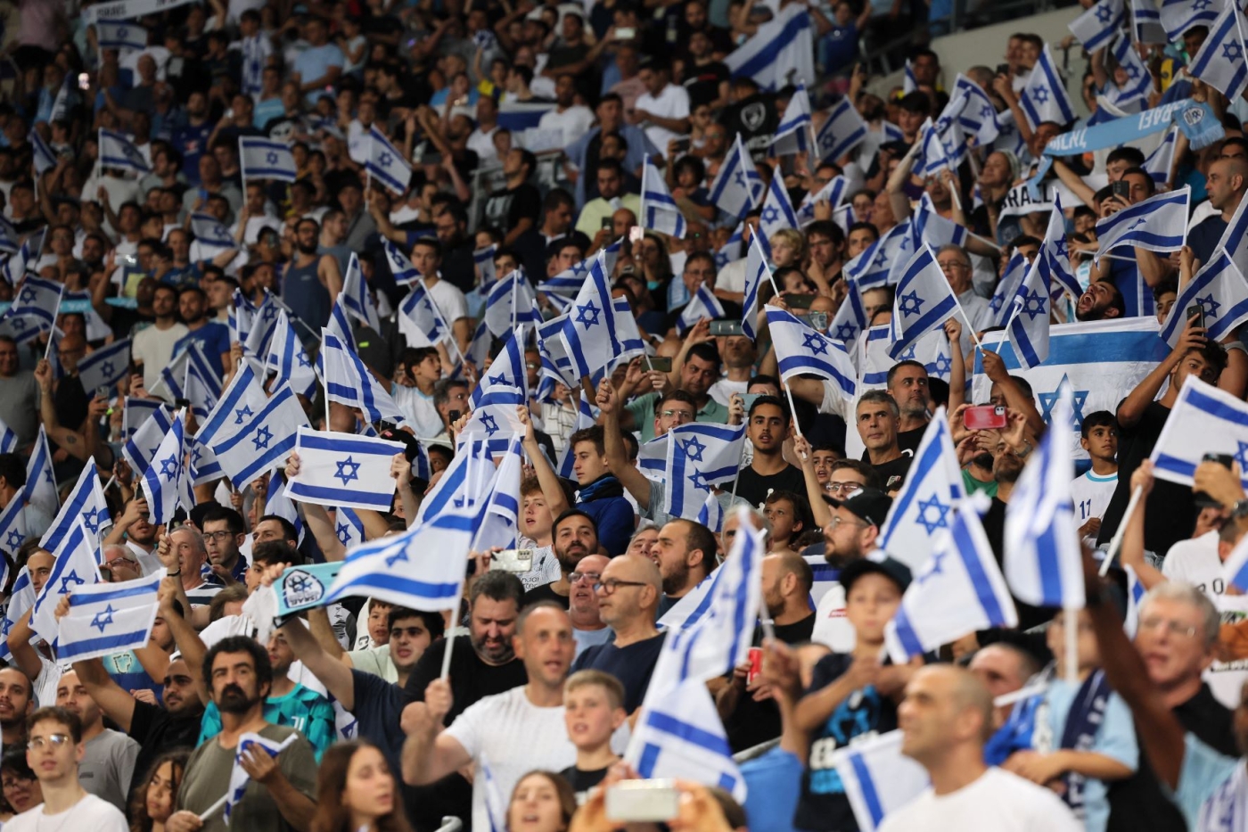 Israel supporters wave the national flag during the UEFA Nations League - League B Group 2 - football match between Israel and Albania at the at the Bloomfield Stadium, in Tel Aviv on September 24, 2022 (AFP)