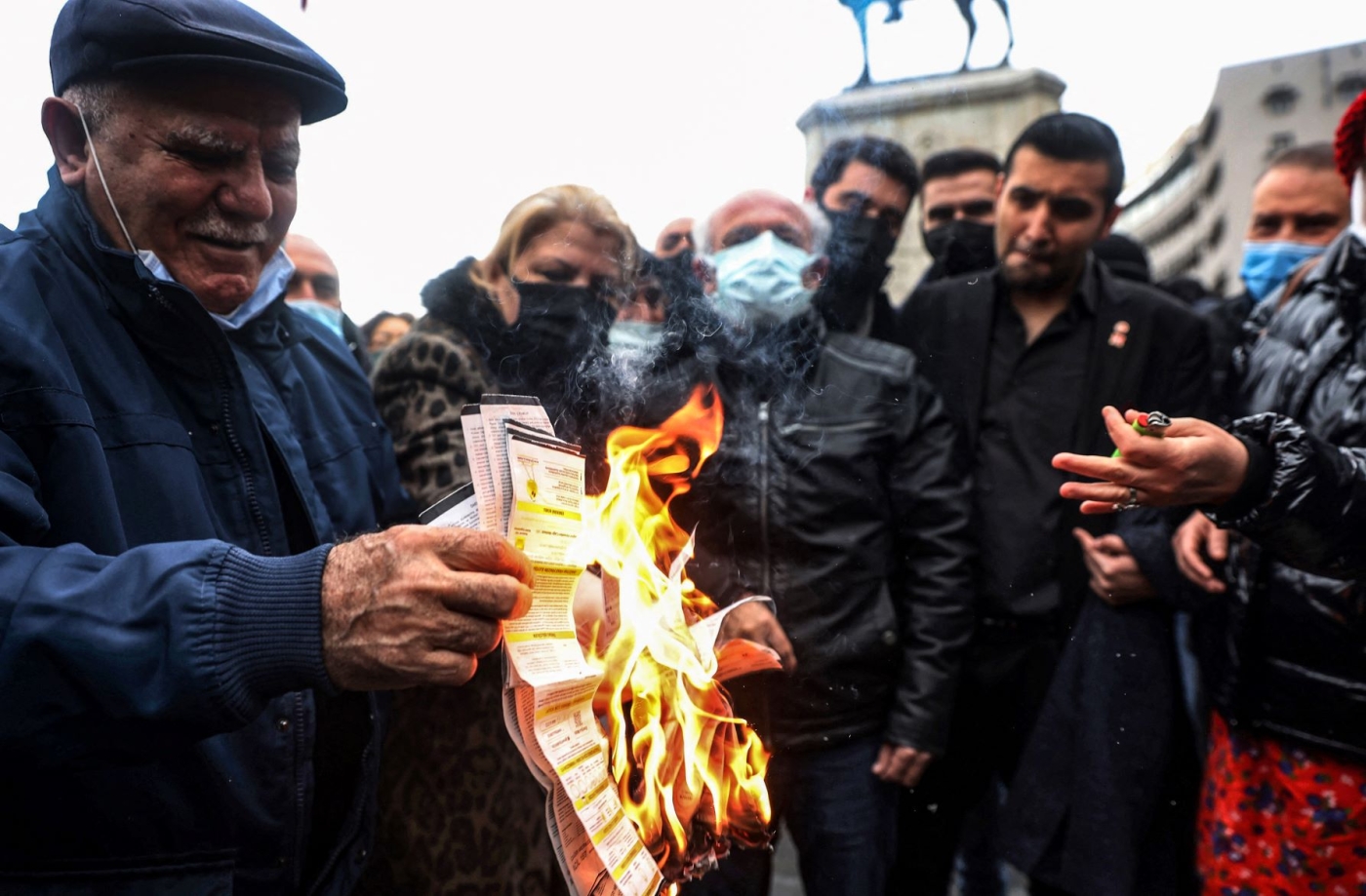 People burn their electricity bills as a protest against high energy prices in on February 9, 2022 (AFP)