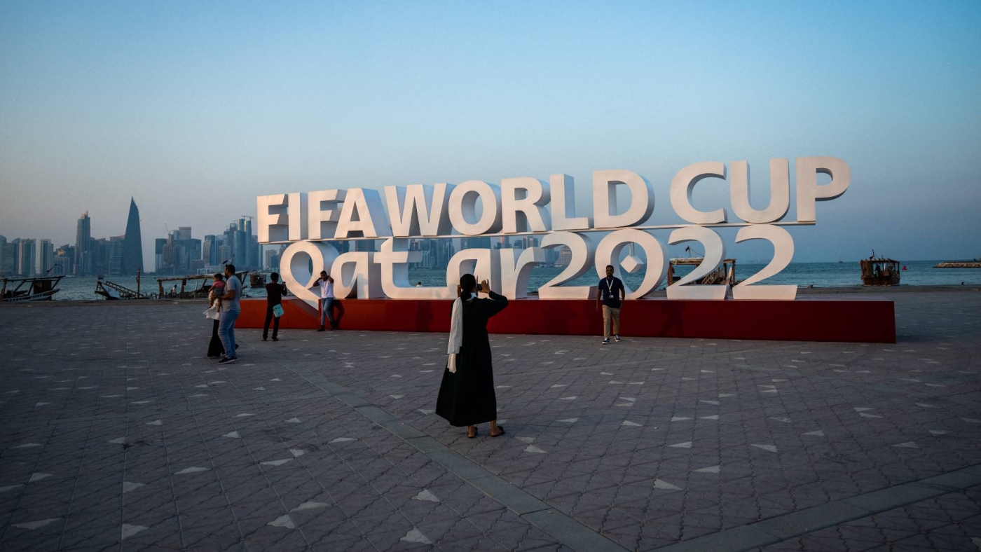 Visitors take photos with a FIFA World Cup sign in Doha ahead of the football tournament, 23 October 2022 (AFP)