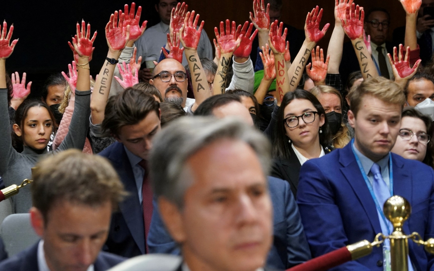 Des manifestants contre la guerre lèvent leurs mains « ensanglantées » derrière le secrétaire d’État américain Antony Blinken lors d’une audition devant la Commission sénatoriale des dotations, le 31 octobre (Reuters)