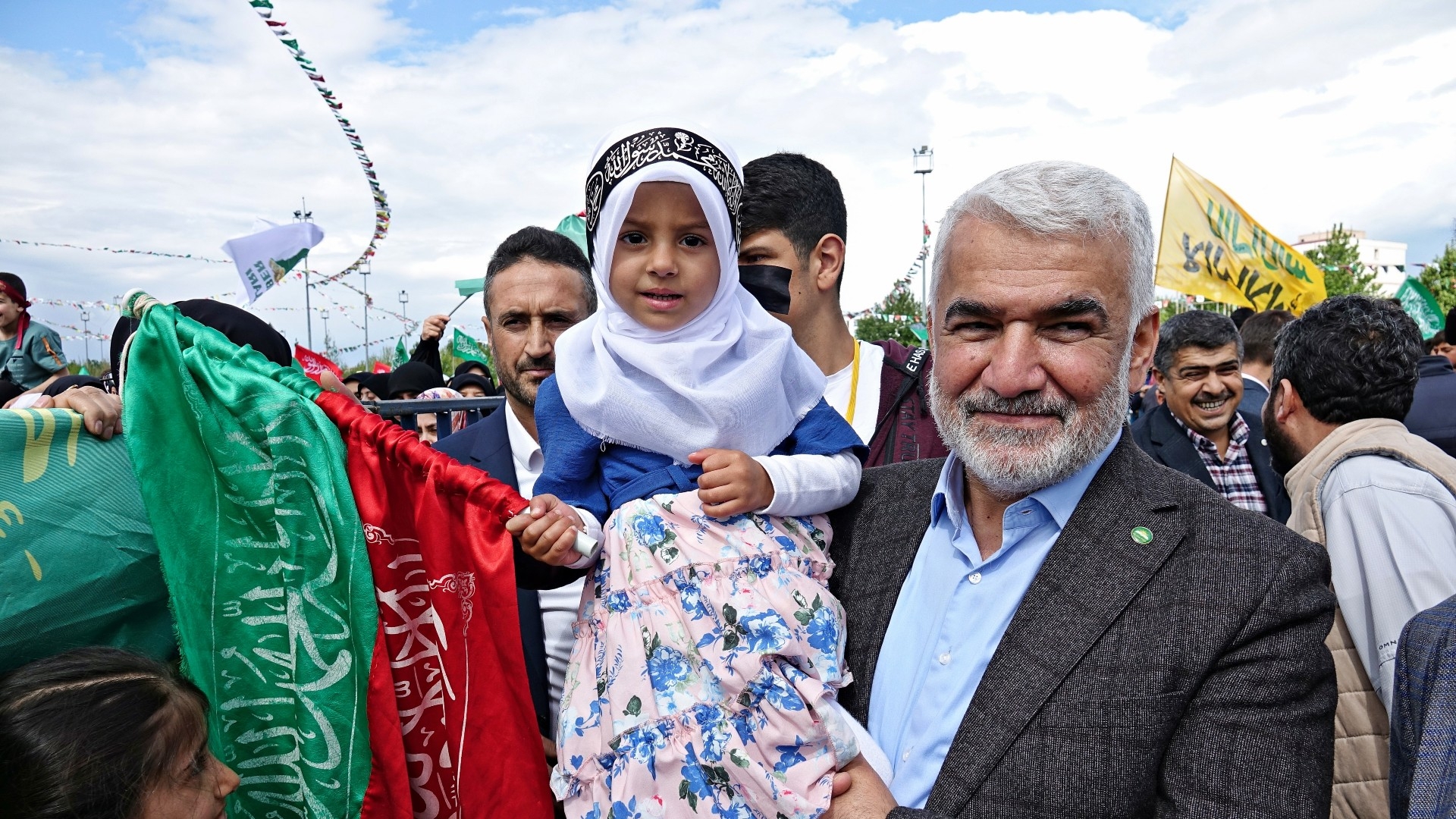 HUDA-PAR Chairman Zekeriye Yapicioglu is seen carrying a girl during a celebration of the prophet's birthday in Diyarbakir 30 April (Reuters)