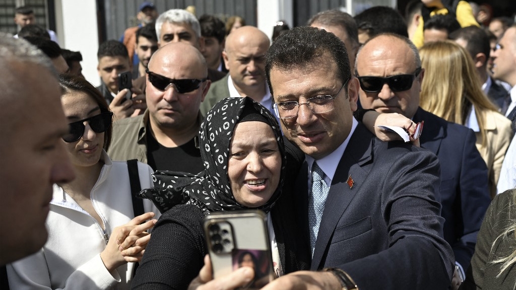 Ekrem Imamoglu (C) poses with supporters after voting in the municipal elections, Istanbul, 31 March 2024 (Yasin Akgul/AFP)