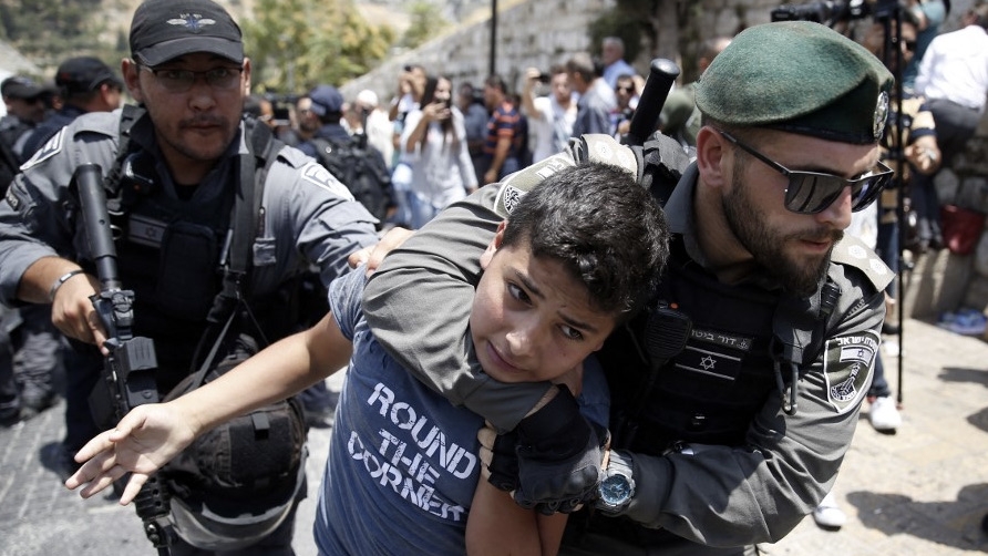 Les forces de sécurité israéliennes arrêtent un jeune Palestinien lors d’une manifestation devant la mosquée al-Aqsa, dans la vieille ville de Jérusalem, le 17 juillet 2017 (AFP)
