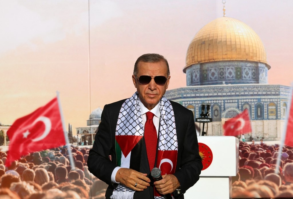 Turkish President Tayyip Erdogan, wearing a scarf with the Palestinian and Turkish flags, stands on the stage during a rally organised by the AKP party in solidarity with the Palestinians in Gaza, in Istanbul on October 28, 2023. (AFP)