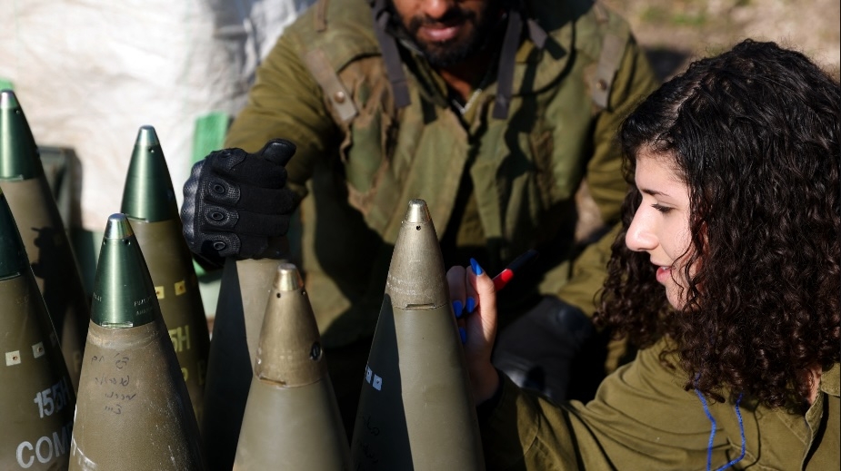 An Israeli soldier signs a bomb in the Upper Galilee in northern Israel, as an artillery unit shells southern Lebanon on 4 January 2024.