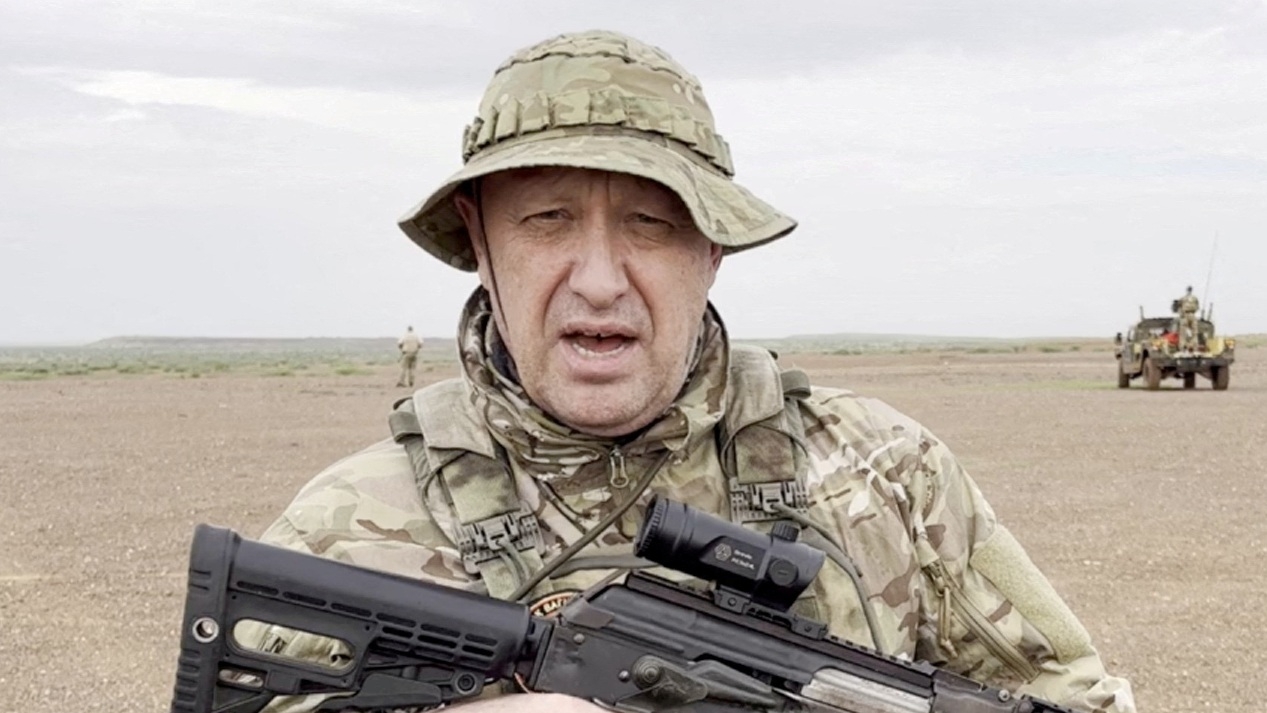 Wagner chief Yevgeny Prigozhin gives an address in camouflage and with a weapon in his hands in a desert area at an unknown location, in an image published on 21 August 2023.