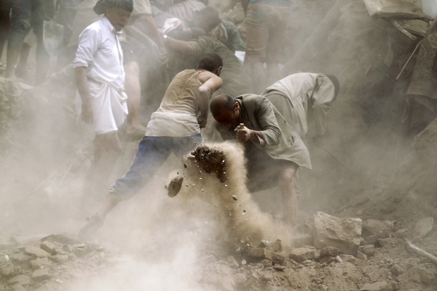 منقذون يبحثون عن ناجين تحت أنقاض المنازل الاثرية المندرجة في قائمة اليونسكو للتراث، التي دمرها القصف الجوي في صنعاء القديمة 12 يونيو 2015. (Mohammed Huwais/AFP) 