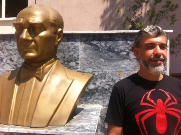 Zafer Asiluan poses next to a statue of Ataturk (MEE / Lauren Williams) 