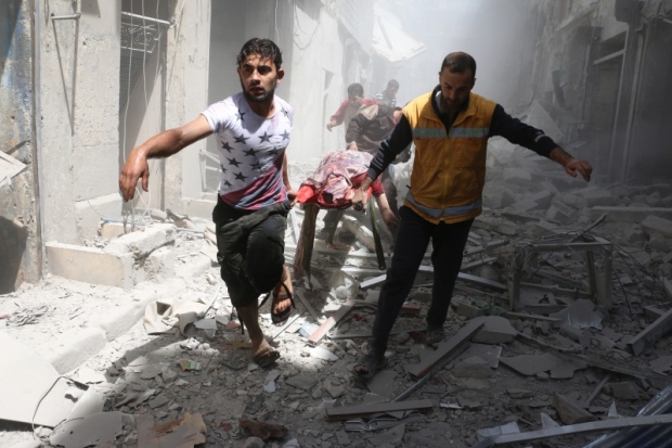 Men carry body on stretcher amid rubble of destroyed buildings after airstrike on rebel-held neighbourhood in Aleppo (AFP) 