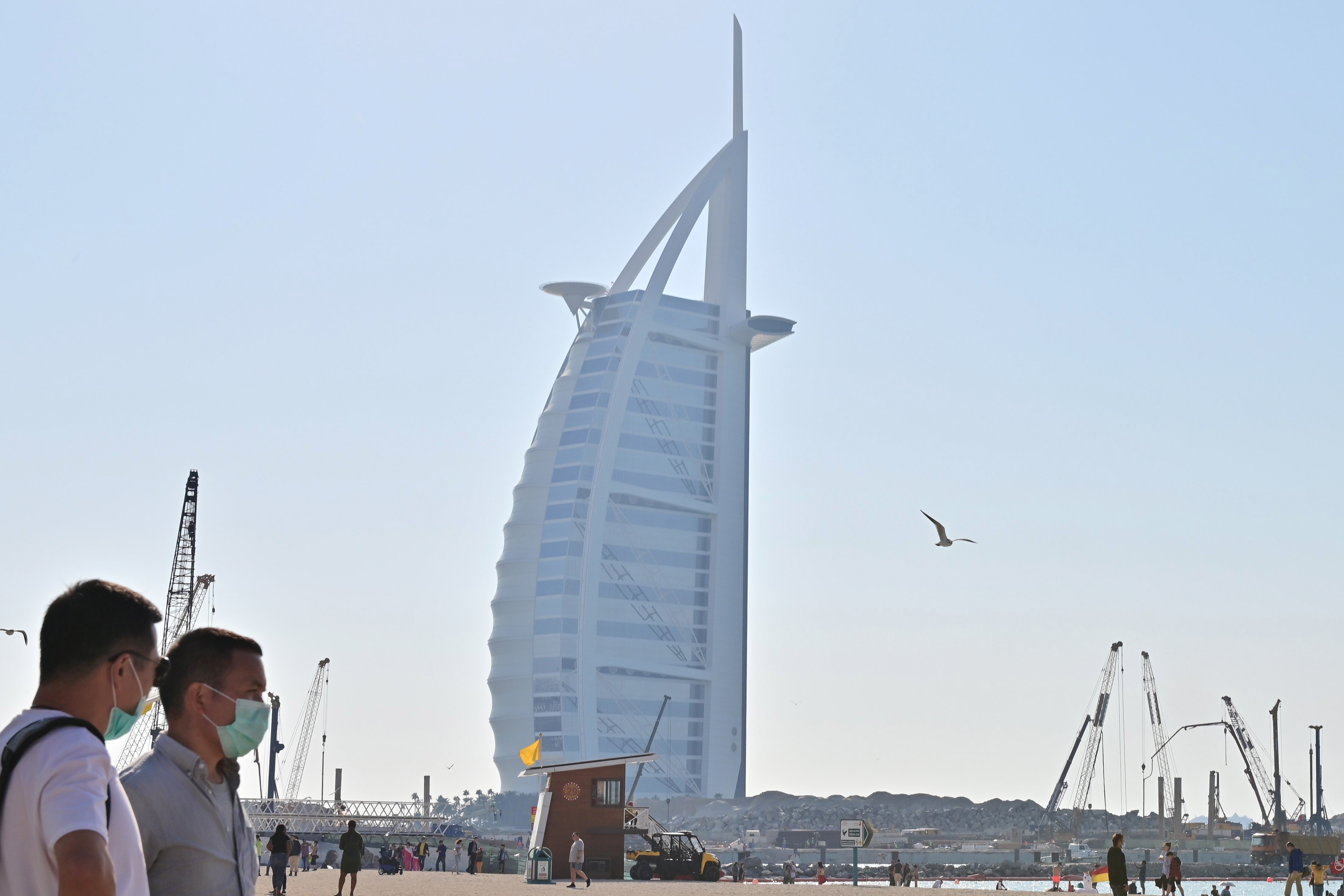Chinese Tourists wearing surgical masks are pictured on a beach next to Burj Al Arab in Dubai on January 29 2020.