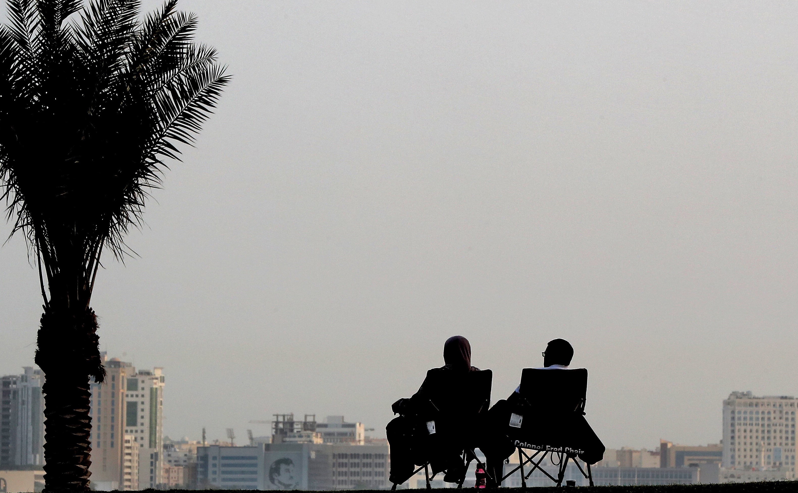 A couple sitting on Doha Corniche (AFP)
