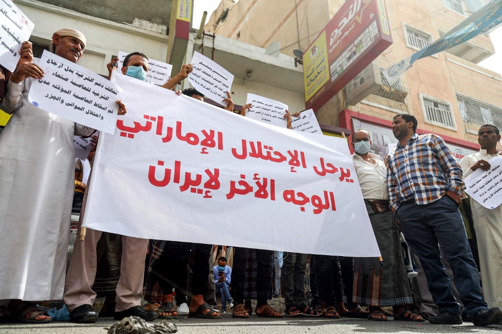 Yemenis hold up a large sign reading in Arabic "away with Emirati occupation, the other side of Iran", as they protest against the United Arab Emirates and the Southern Transitional Council (STC) in the country's third city of Taez on June 24, 2020