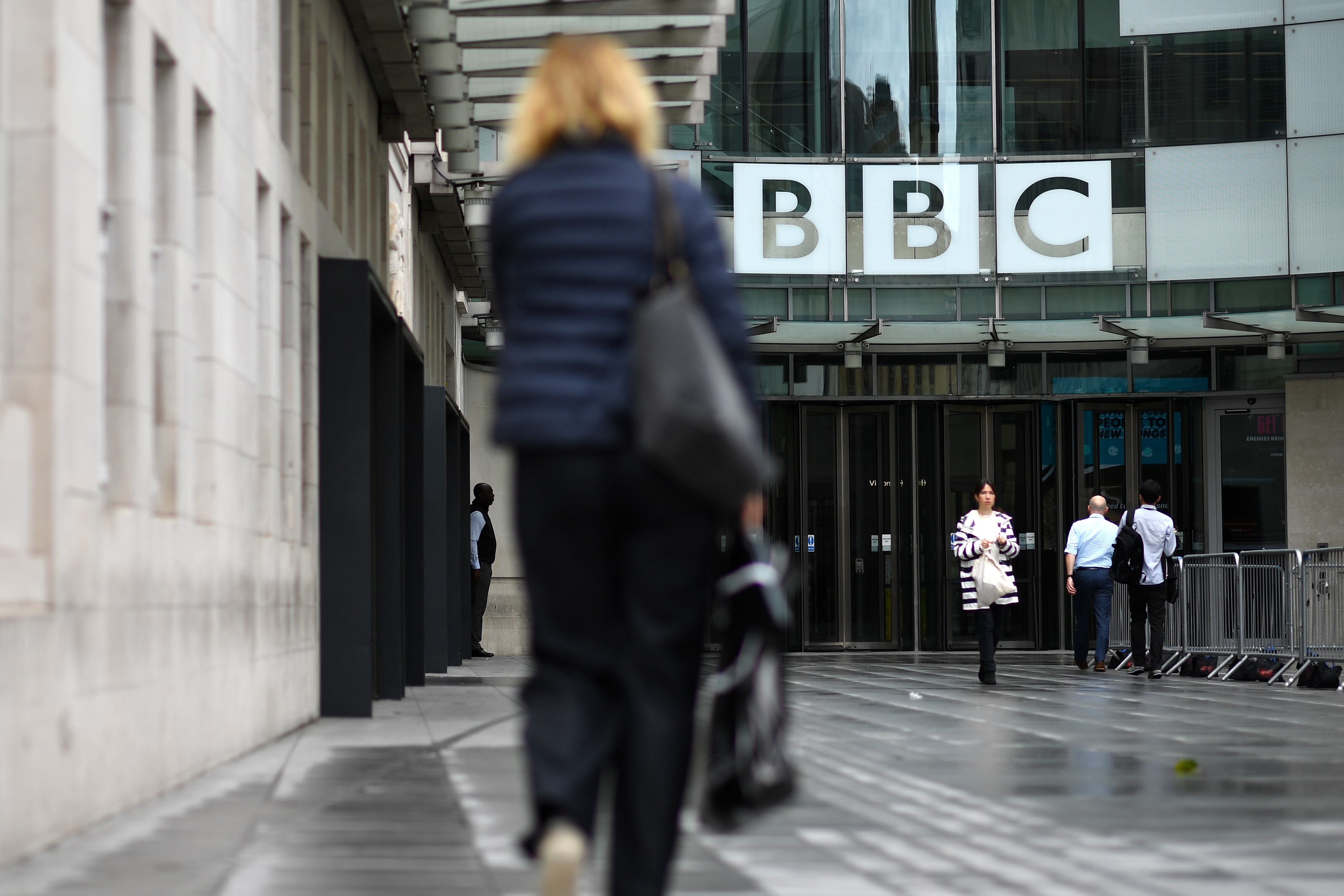 People walk outside the BBC headquarters in Portland Place, London on July 2, 2020. 