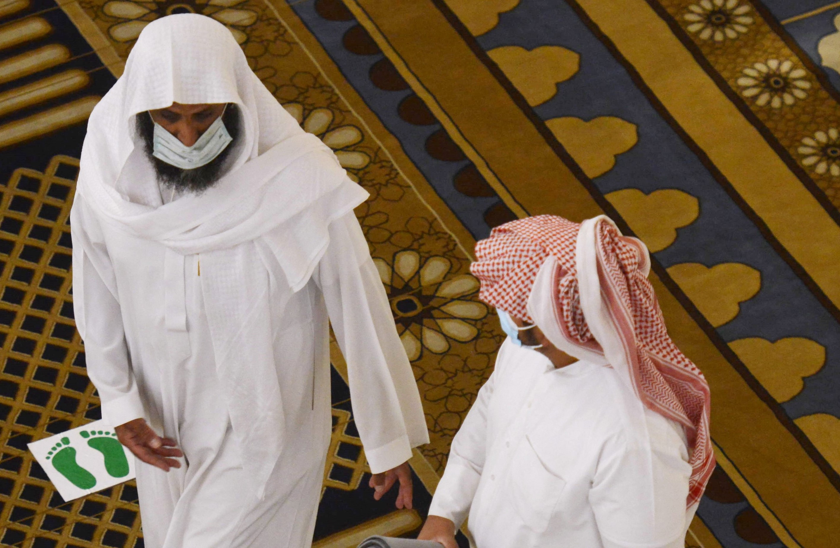 Saudi worshippers wearing face masks to prevent the spread of Covid-19 walk at the al-Rajhi mosque in the Riyadh, on August 31, 2020.