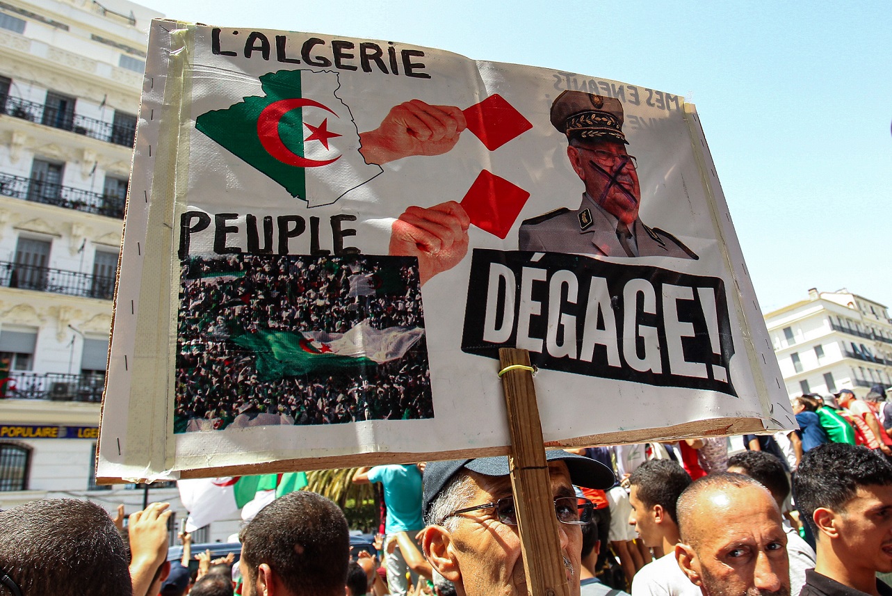 Un manifestant algérien brandit une pancarte critique à l’égard d’Ahmed Gaïd Salah à Alger le 12 juillet 2019 (AFP)