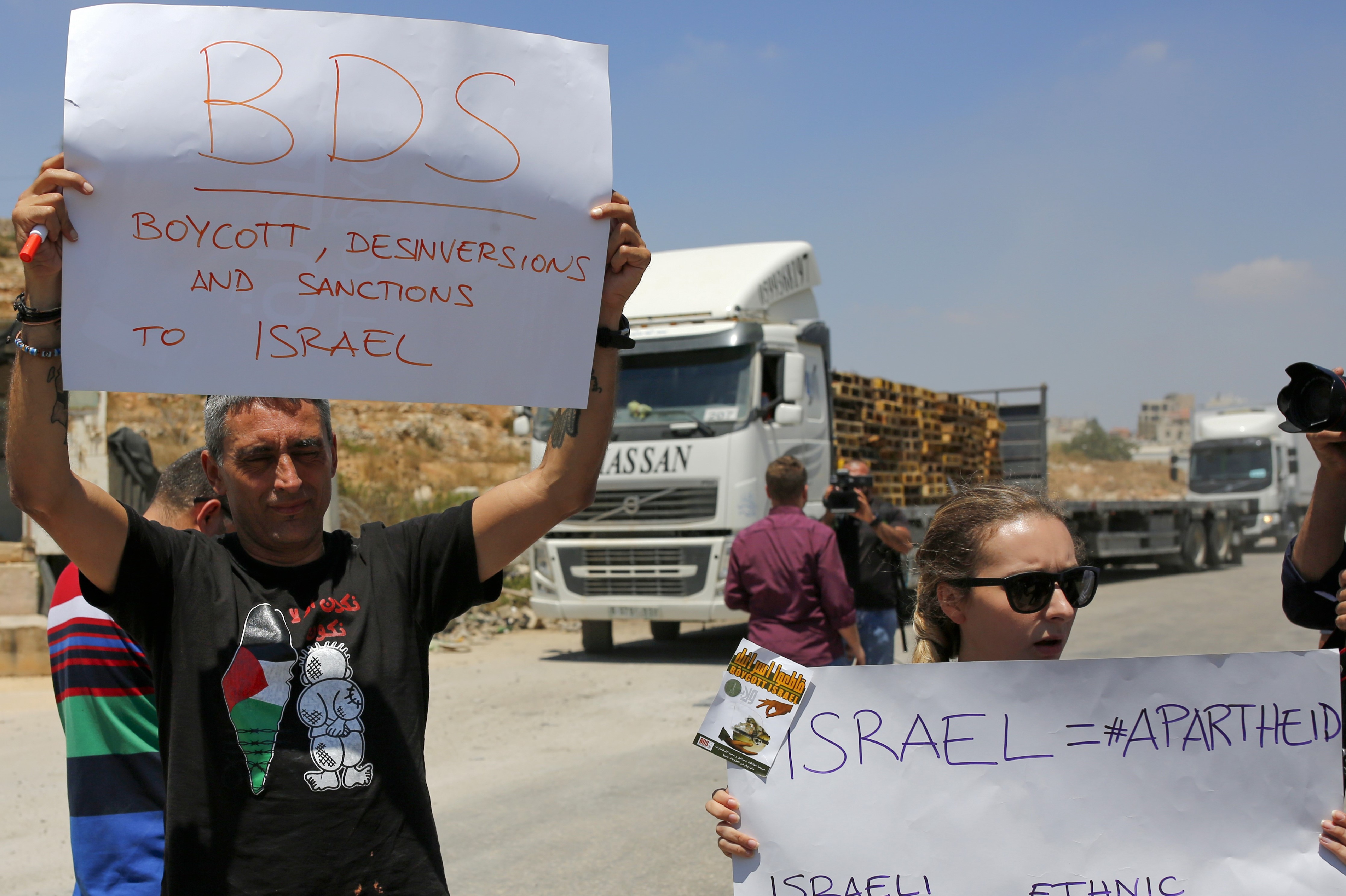    Palestinians demonstrate at the Ofer Israeli checkpoint near Ramallah, through which Israeli goods are usually transported to the West Bank, calling on Palestinians to boycott such imports, on August 6, 2019