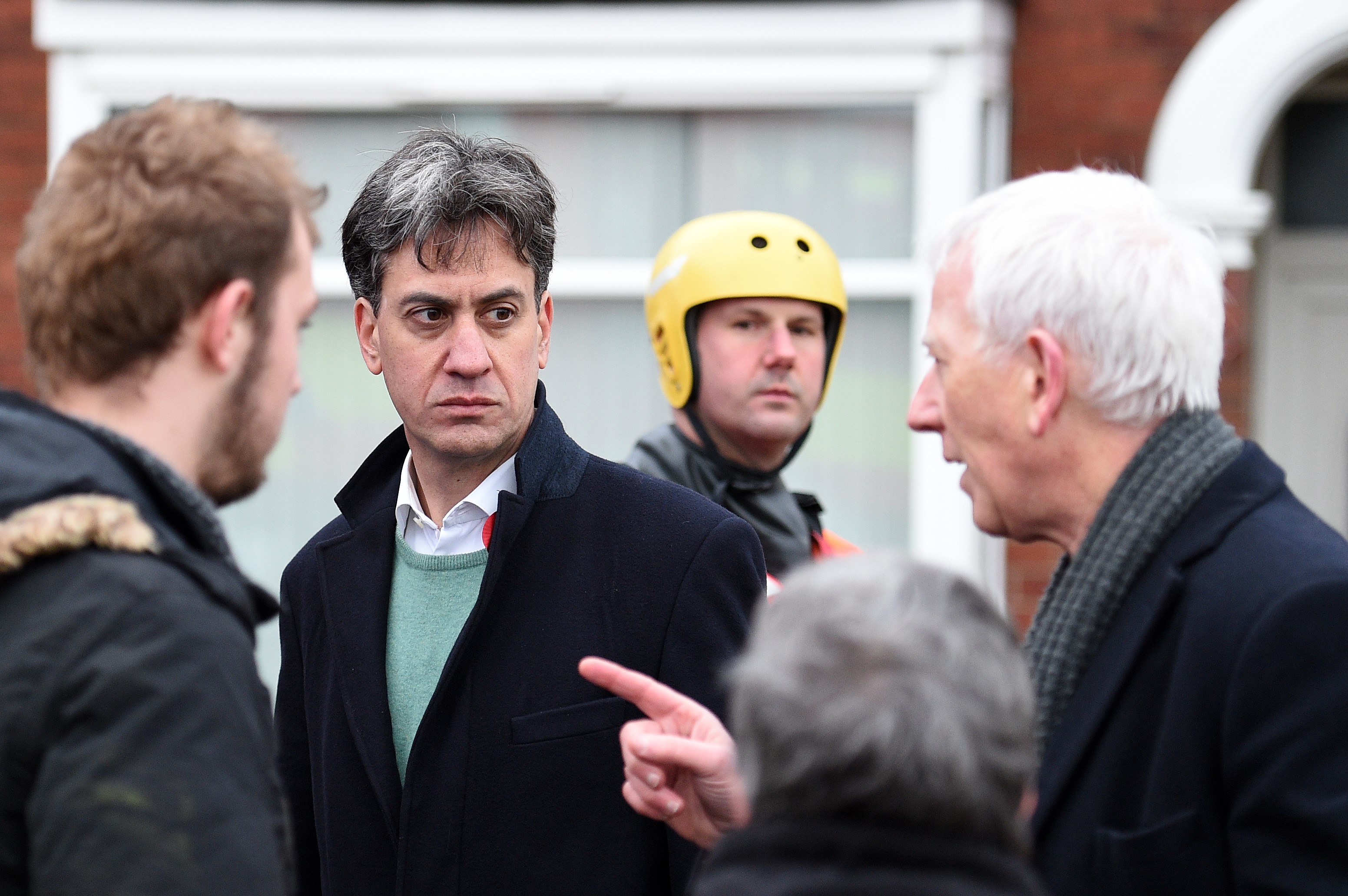 Labour MP for Doncaster North, Ed Miliband (2L), talks with residents on a flooded street in Doncaster, northern England on November 8, 2019,