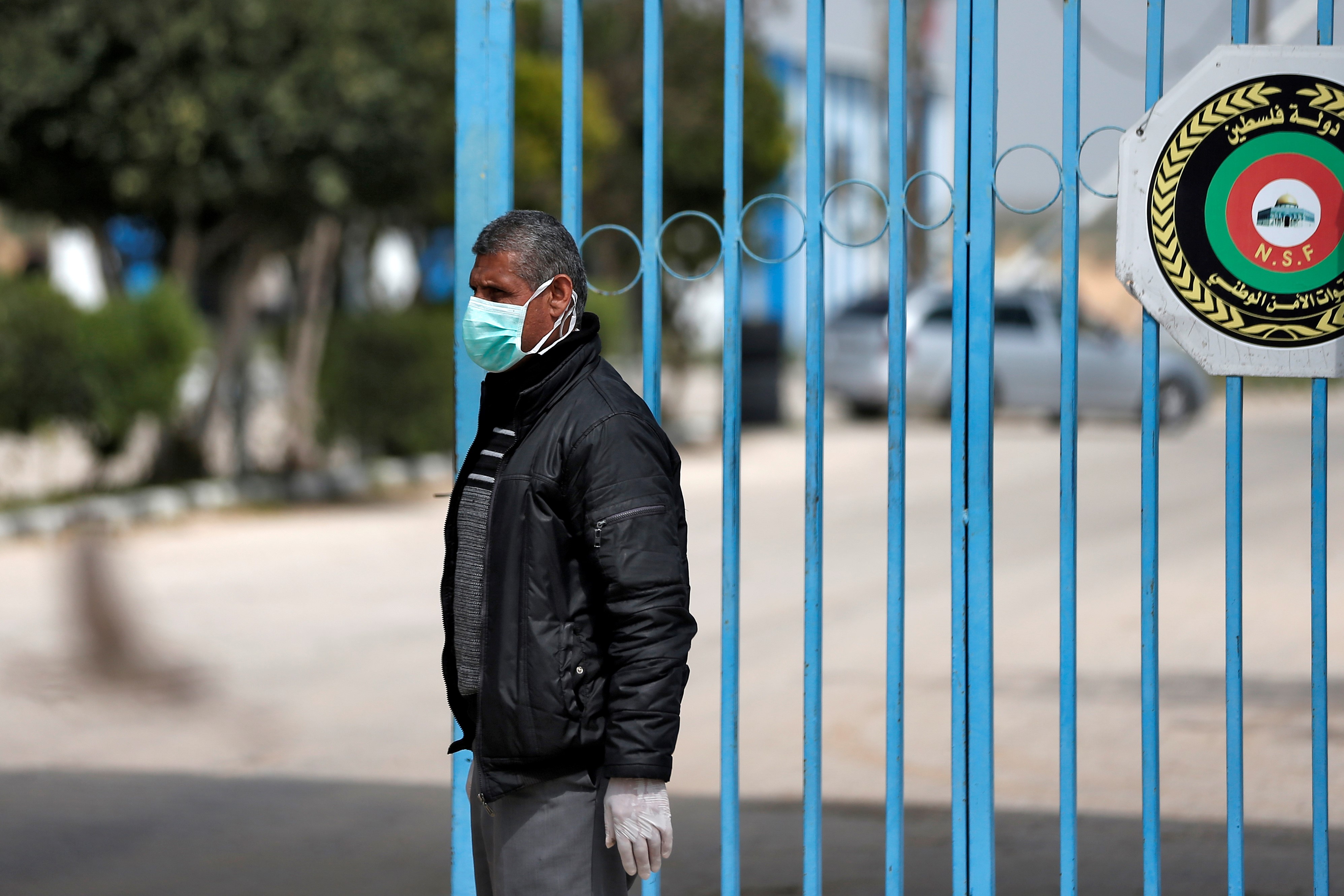 A Palestinian health ministry officer stands at the gate of the Erez crossing with Israel near Beit Hanun in the northern Gaza Strip on March 15, 2020. 