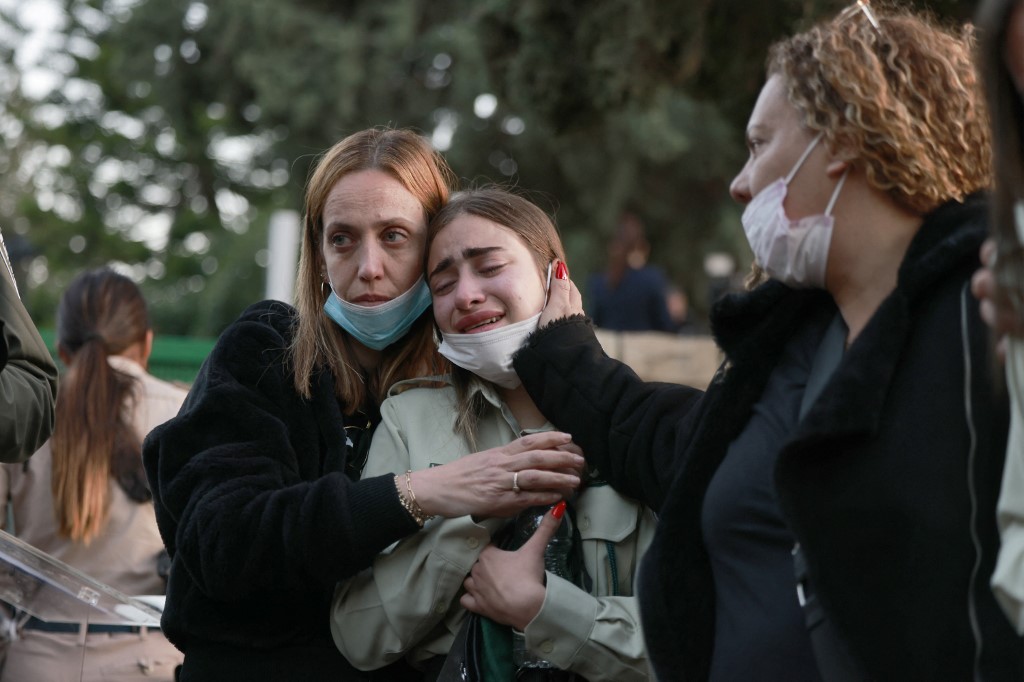 Une collègue pleure une victime de la fusillade au cours de ses funérailles, le 27 mars 2022 (AFP)