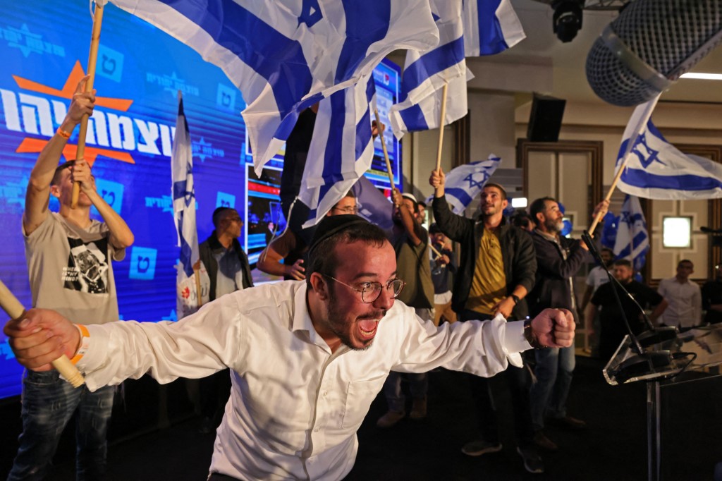 Supporters of Israel's Jewish Power cheer at campaign headquarters in Jerusalem after the end of voting in the national elections, on 1 November 2022 (AFP)