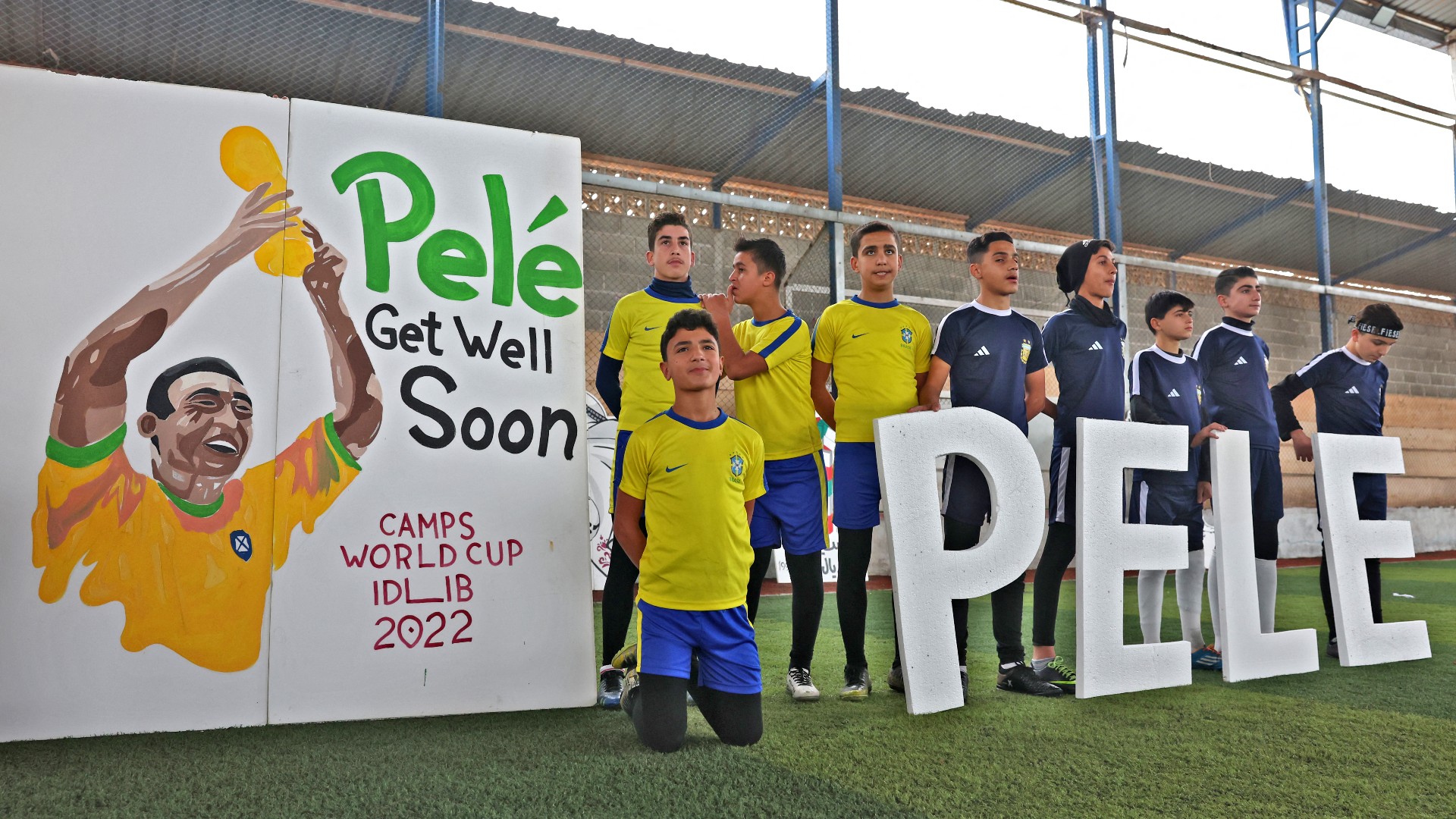 Displaced Syrian children pay tribute to Brazilian football legend Pele before a match at the Hazano stadium in northern Idlib, on 9 December (AFP)
