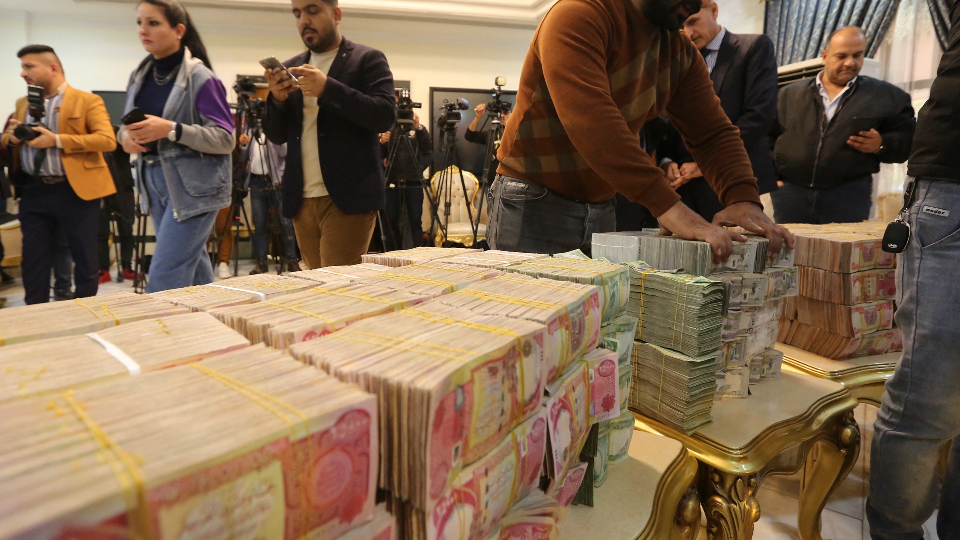 Journalists arrive for a news conference to announce the recovery of 4bn dinars, reportedly part of the $2.5bn fraudulently stolen from the tax authorities (AFP)