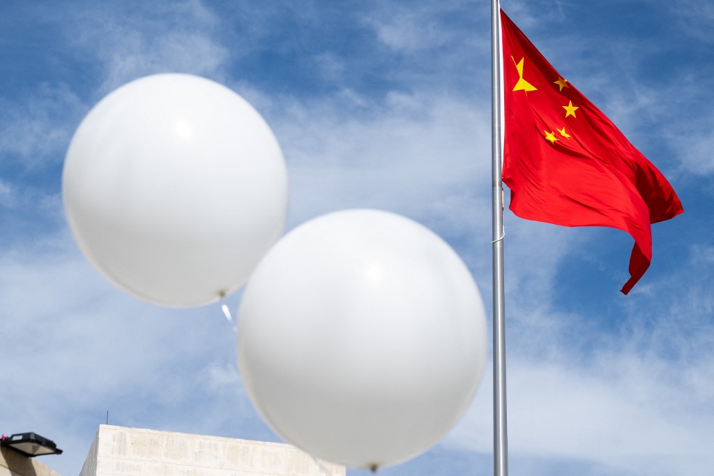 Two white balloons are used during a protest outside the Chinese embassy in Washington, DC, 15 February 2023 (AFP)