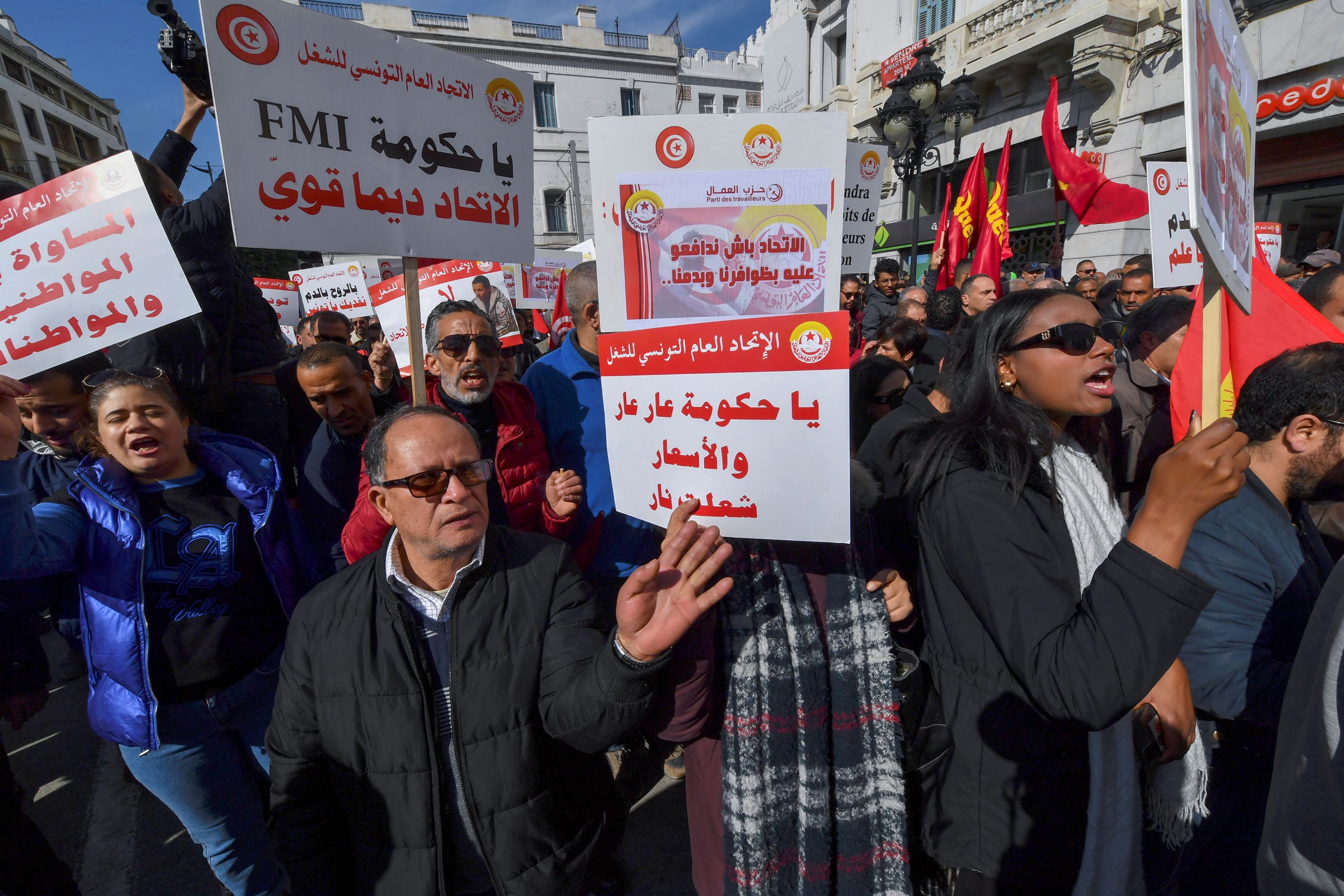 Demonstrators lift placards during an anti-government rally called for by the powerful trades union federation UGTT in Tunis, on March 4, 2023 (AFP)