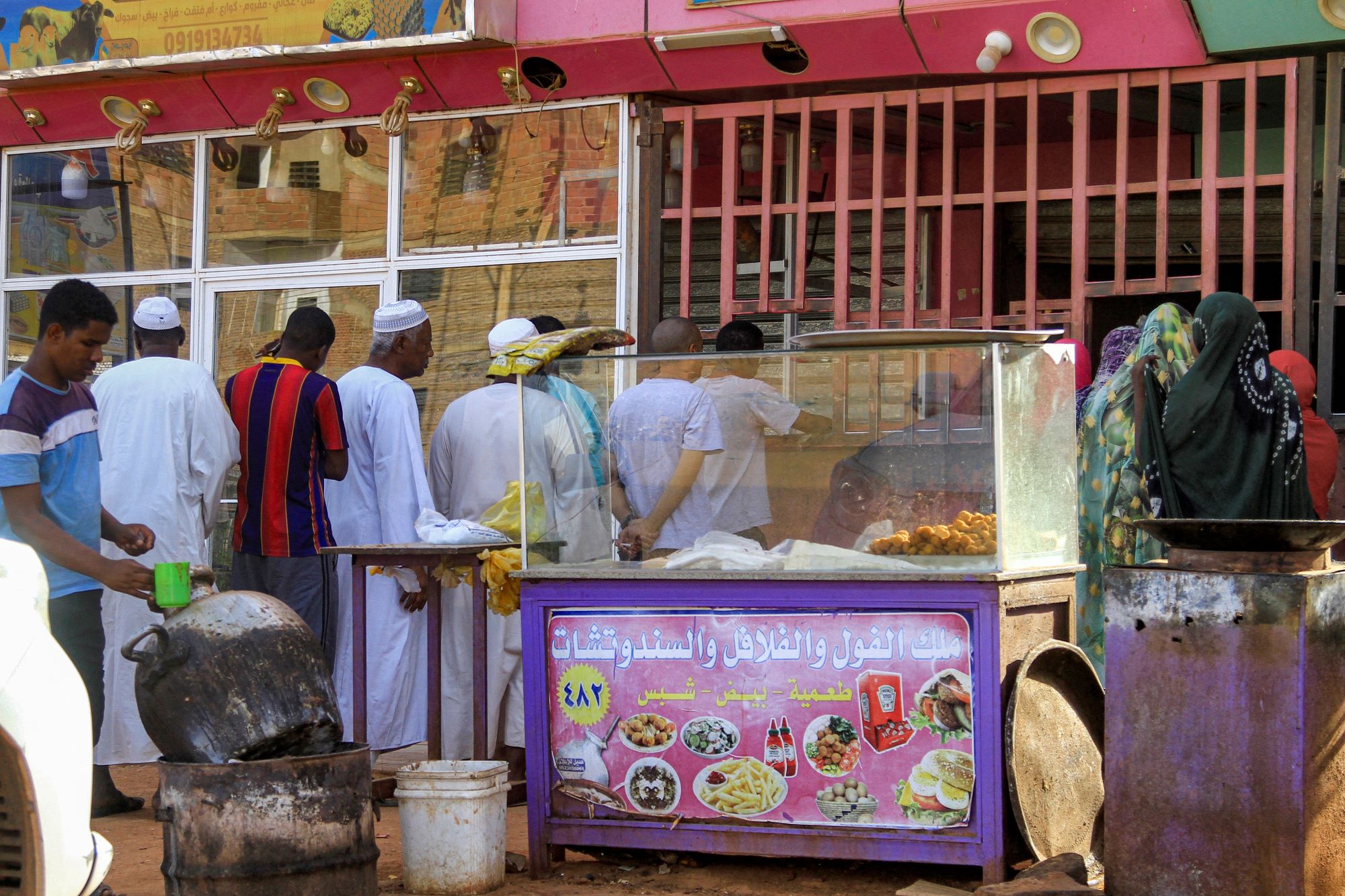People queue for bread outside a bakery amidst a food crisis in the south of Khartoum on April 17, 2023 (AFP)
