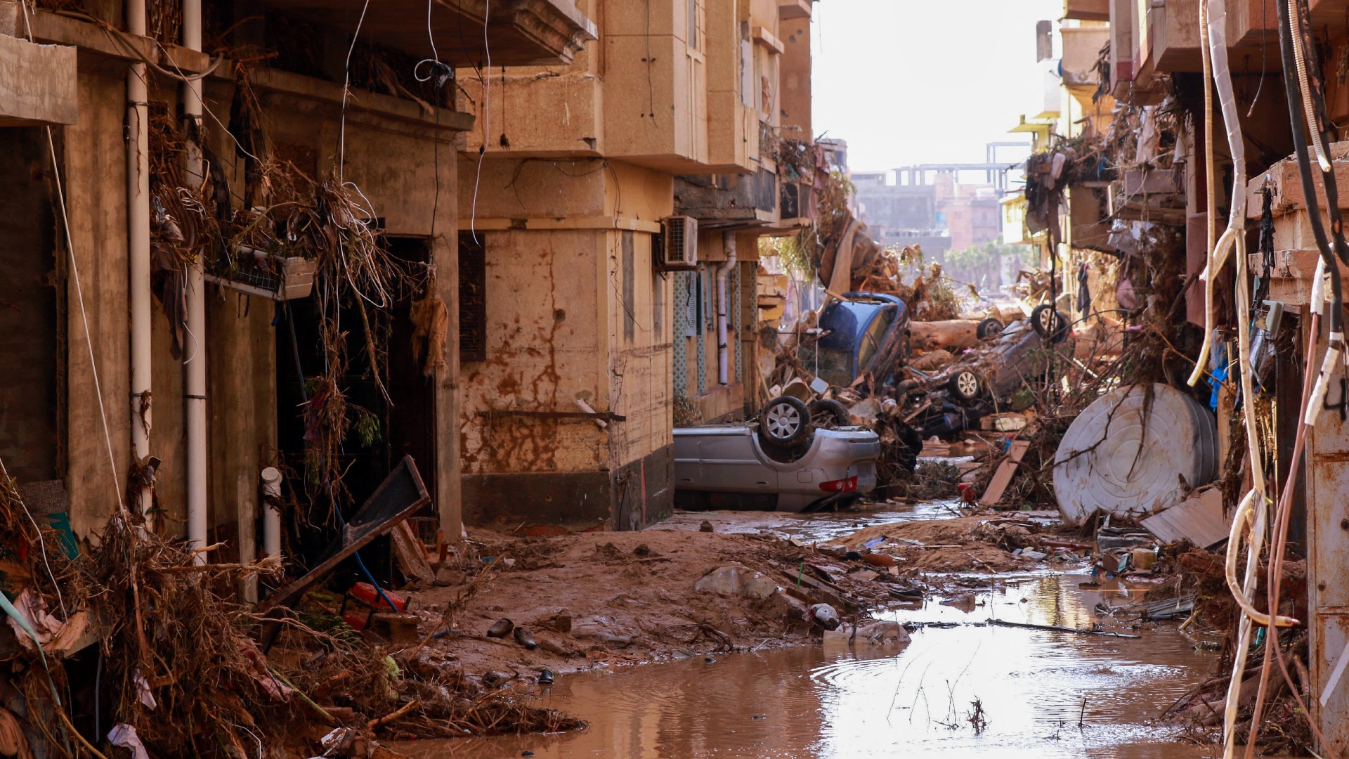Overturned cars lay among other debris caused by flash floods in Derna, eastern Libya, on 11 September (AFP)