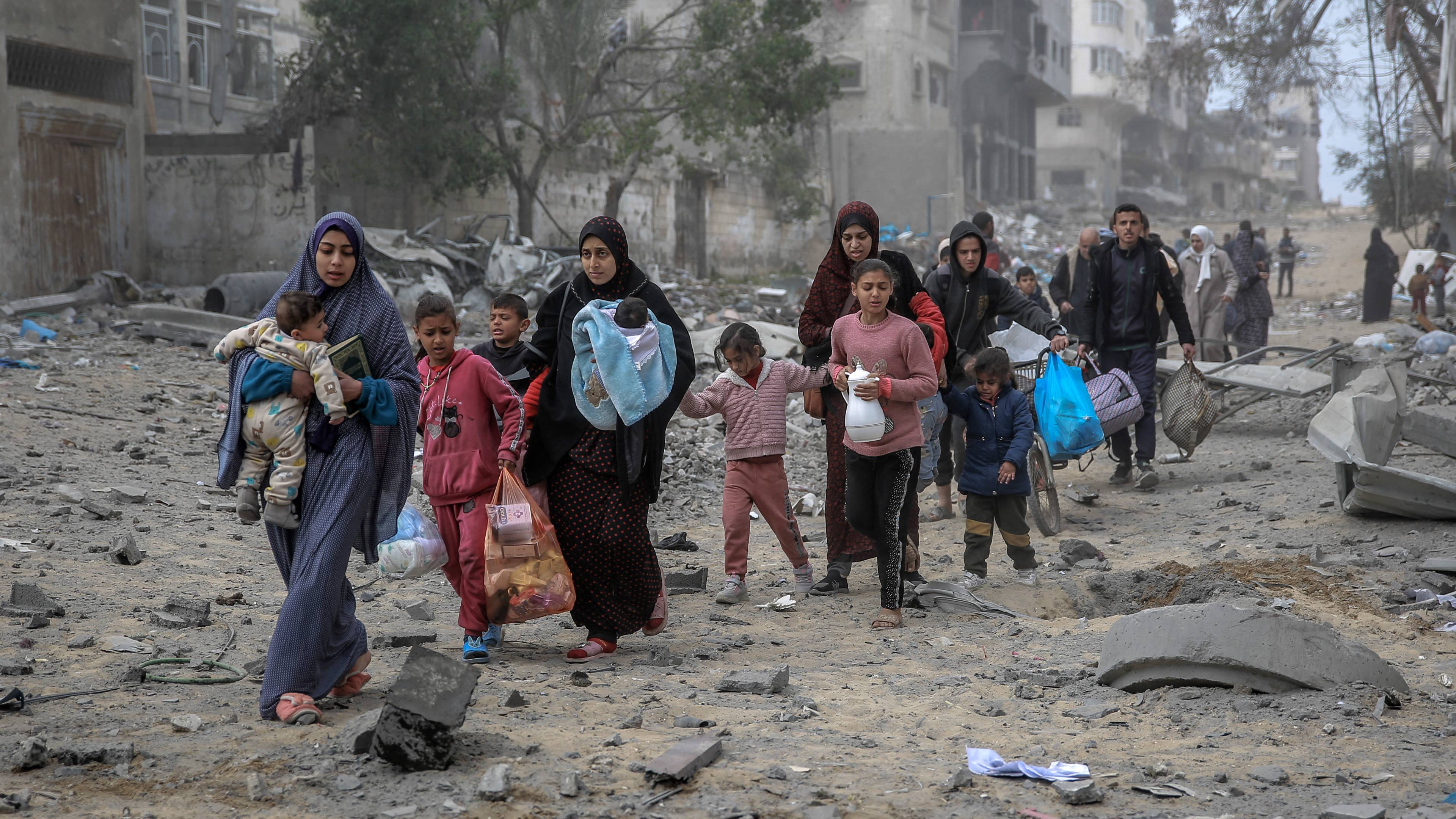 Palestinian women and children flee the area after Israeli bombardment in central Gaza City on 18 March 2024 (AFP)