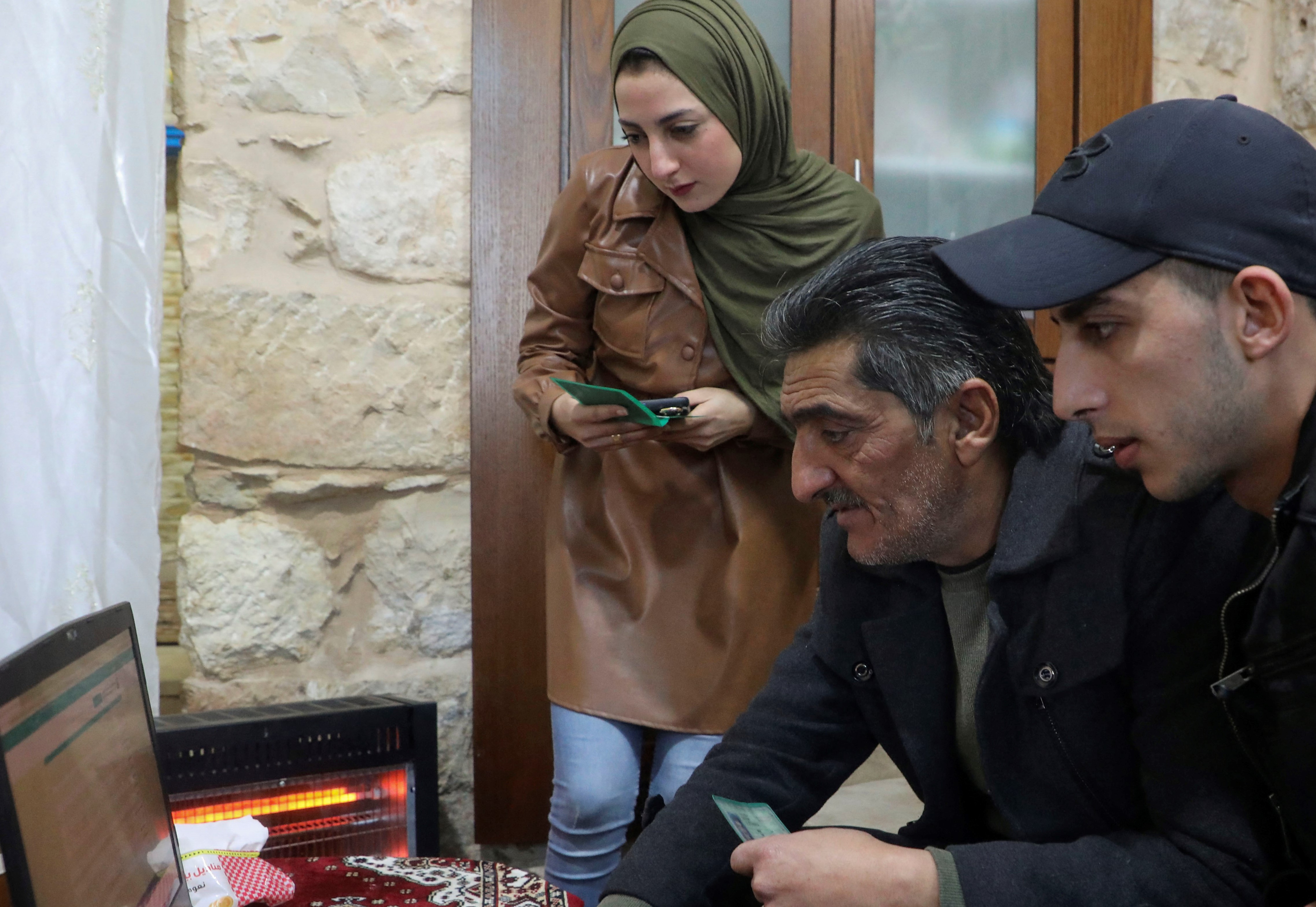 Members of the Palestinian Abu Shamsiyeh family register to vote through the Palestinian Elections Committee website, at home in the West Bank city of Hebron, on January 22, 2021 AFP